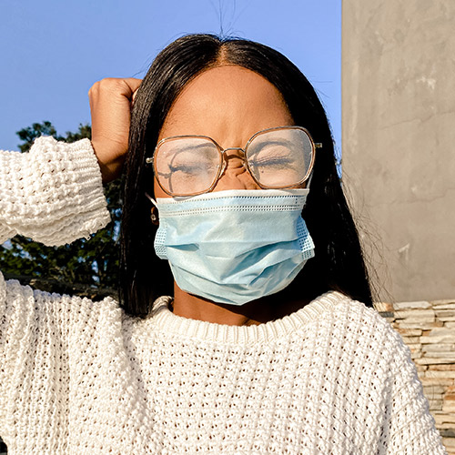 A woman wearing glasses and a face mask