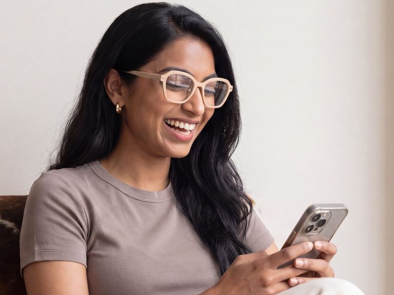 A woman smiling at her phone