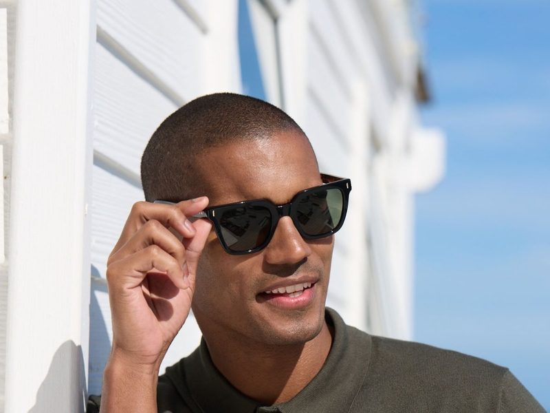 A man adjusting his sunglasses